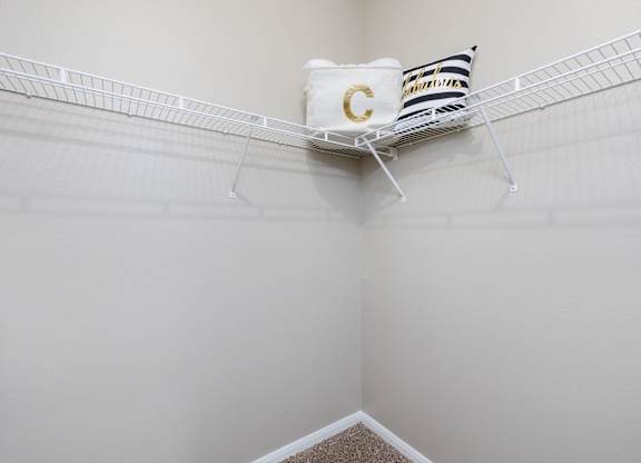 A white shelf with a pillow and a bag with the letter C on it at Clear Creek Meadows Apartments, Copperas Cove, Texas