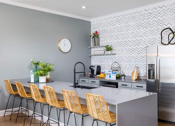 a kitchen with a large island and yellow chairs at Clear Creek Meadows Apartments, Copperas Cove