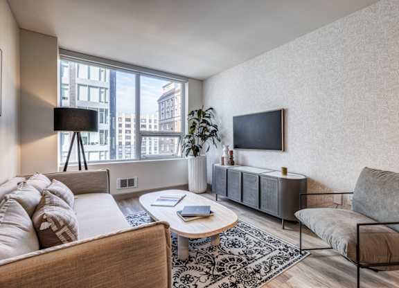 a living room with a couch and a chair and a television