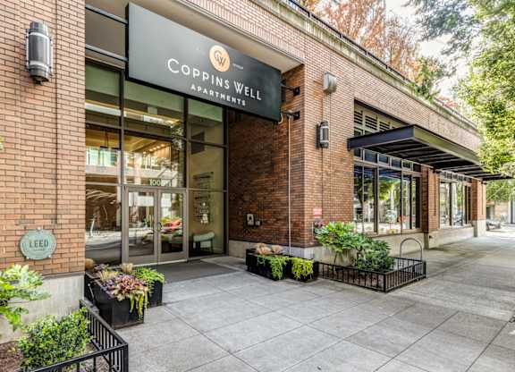 the facade of a building with a sign that reads Coppins Well Apartments