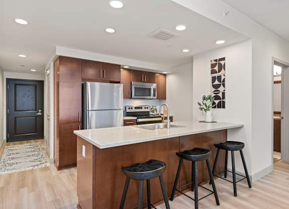 a kitchen with a large island with three stools in front of it