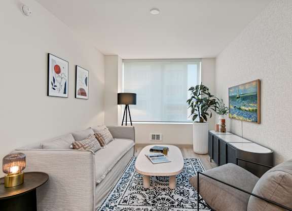 two couches and a coffee table in a living room with a large window