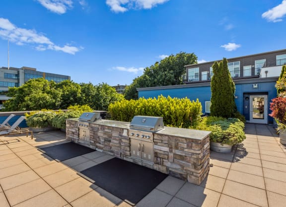 a fire pit on the roof of a building with a blue sky in the background  at Dexter Lake Union, Seattle, WA