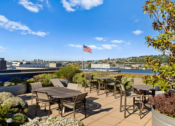 an outdoor patio with tables and chairs and an american flag  at Dexter Lake Union, Seattle, WA