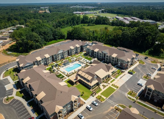 an aerial view of a hotel and apartments with a swimming pool
