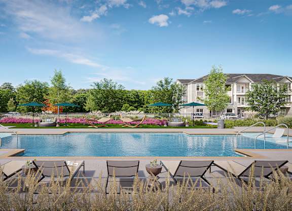 A pool surrounded by chairs and trees at Easton at Mountain Island apartments in Charlotte, NC.