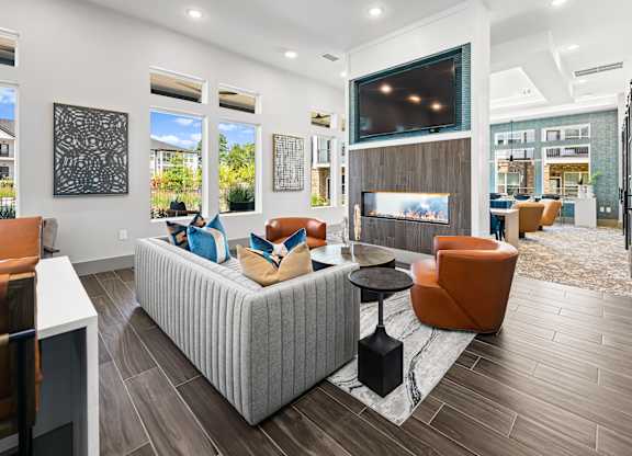 A modern living room with a grey sofa and orange chairs.