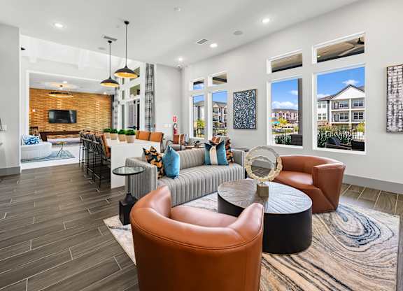 A modern living room with a wooden floor and a variety of seating options.