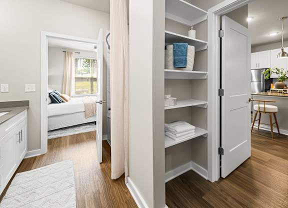 A white interior of a room with a kitchen area and a bedroom.