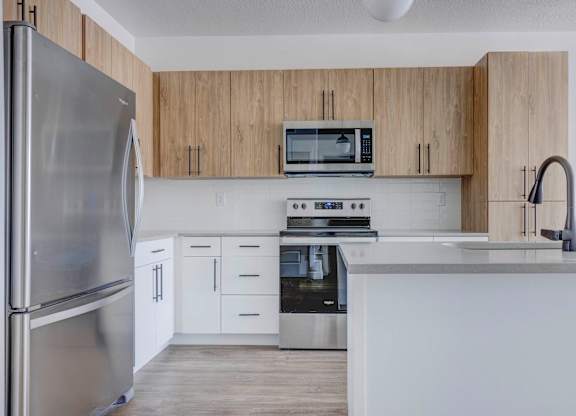 a kitchen with white cabinets and stainless steel appliances