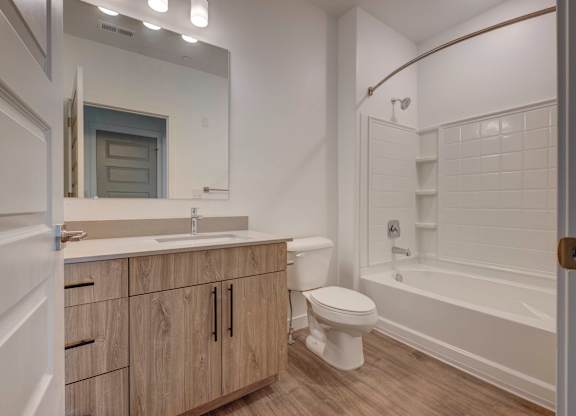 a bathroom with a toilet sink and shower and a mirror