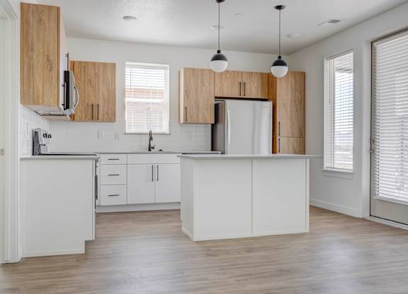 an empty kitchen with white cabinets and a white counter top