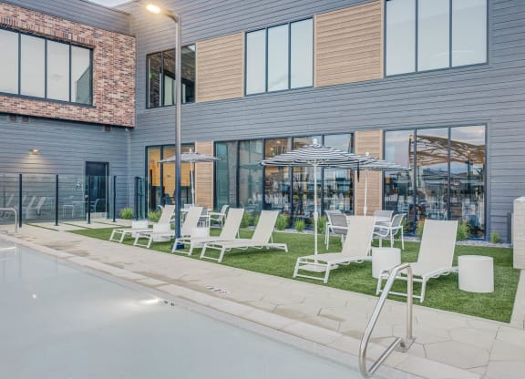 a row of lawn chairs and umbrellas in front of a building