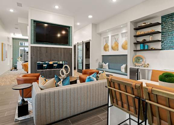 A living room with a grey couch and a wooden chair.