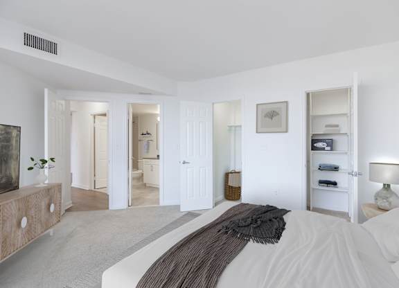 a bedroom with a bed and a dresser and a bathroom