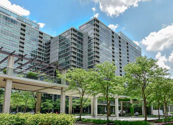 A modern building with glass windows and a green lawn in front.