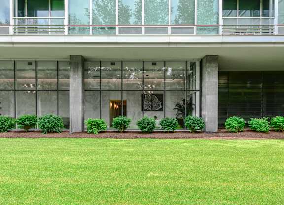 A building with a green lawn in front.