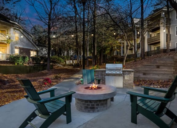 a backyard with a fire pit and chairs