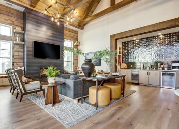 a living room with a gray couch and a table with stools