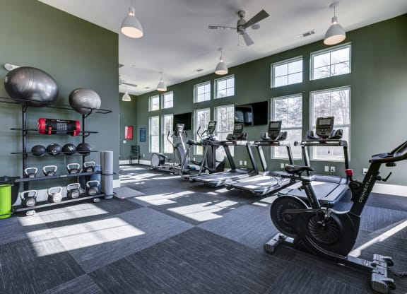 a gym with weights and cardio equipment at the belgard apartments