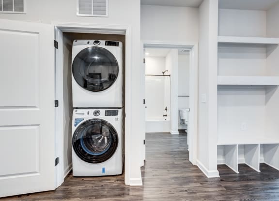 a white washer and dryer in a room with white walls and a door