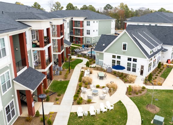 an aerial view of a group of houses with tables and chairs