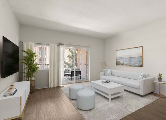 A living room with a white couch, a coffee table, and a television.