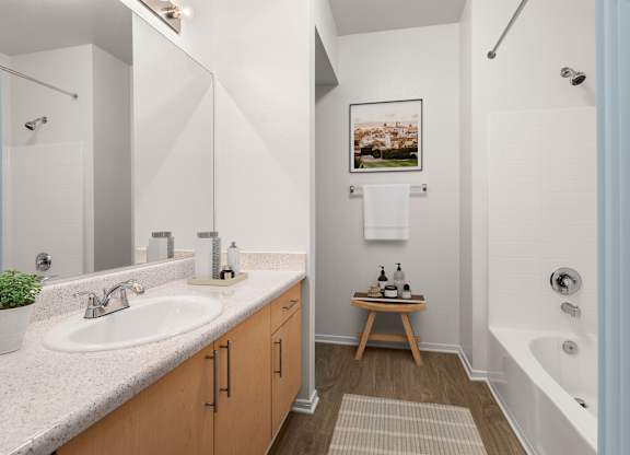 A bathroom with a white sink and a white bathtub.