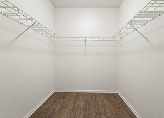 Closet  with white walls and wooden floor.
