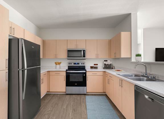 A kitchen with a black refrigerator, black microwave, black oven, and black dishwasher.