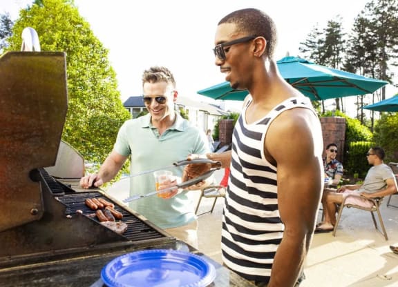 Couple of men standing in front of a grill at The Madison at Adams Farm, Greensboro, NC