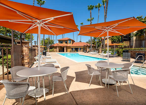Swimming pool with tables and umbrellas next to it at Bella Terra, Vista, California, 92081