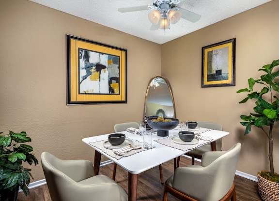 A dining room with a white table and chairs.