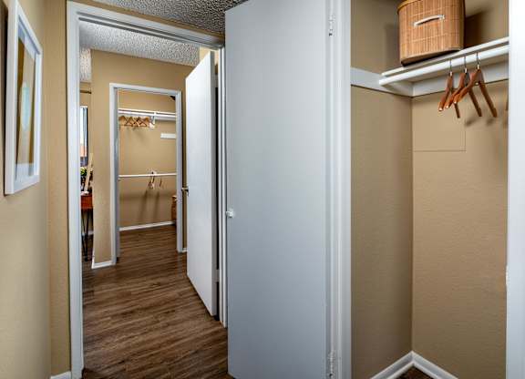 A white door is open to a hallway with a coat rack.