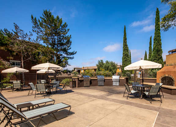 Patio with tables and chairs and umbrellas at Casoleil, San Diego, CA, 92154