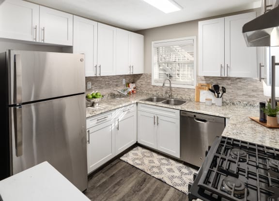 a kitchen with white cabinets and a stainless steel refrigerator