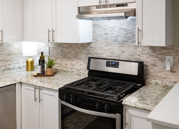 a kitchen with white cabinets and a stove top oven