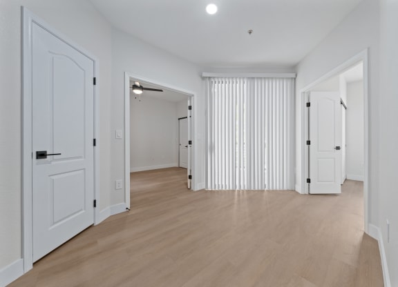 a bedroom with hardwood floors and white walls