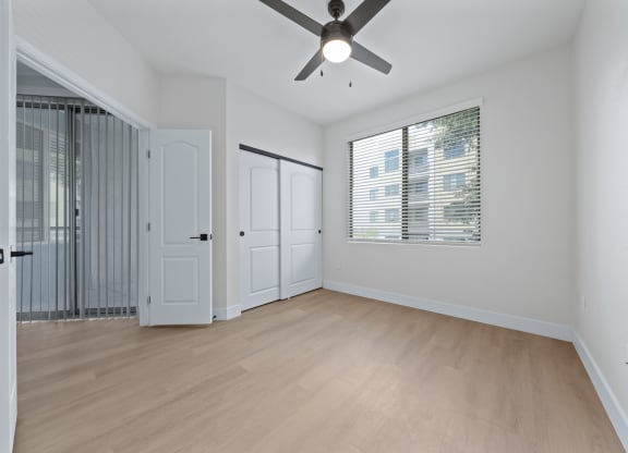 a bedroom with hardwood floors and a ceiling fan