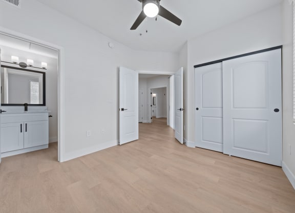 a bedroom with two closets and a ceiling fan