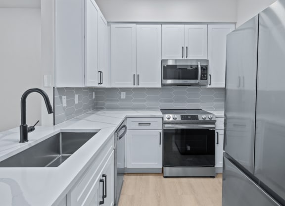 a kitchen with white cabinets and stainless steel appliances