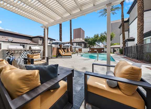 A patio with a pool and a white canopy.