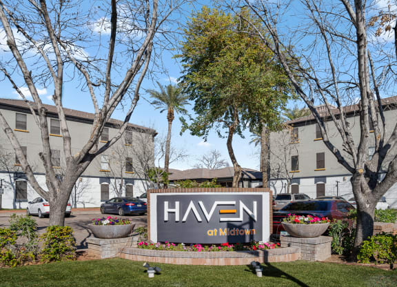 a large sign in front of a building with trees