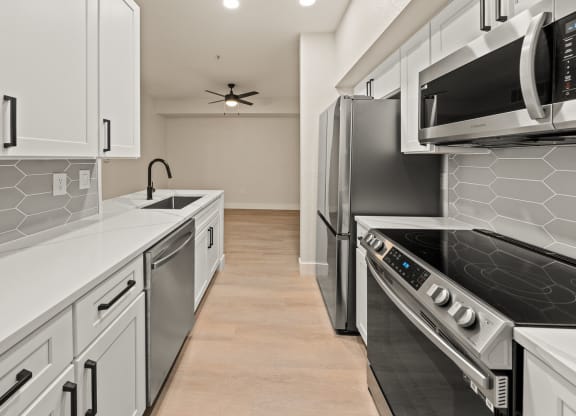 a kitchen with white cabinets and stainless steel appliances