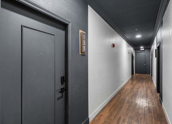 A hallway with a door on the left and a door on the right.