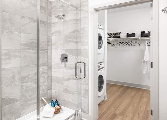 A bathroom with a walk-in shower and a laundry room.