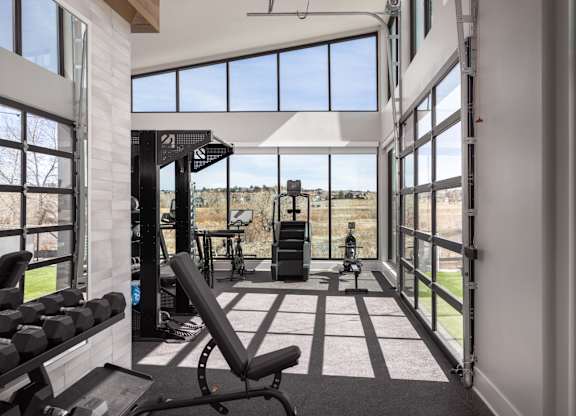 A gym with a view of the outdoors through large windows.