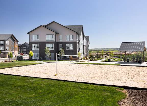 A sand volleyball court is located in front of a building.