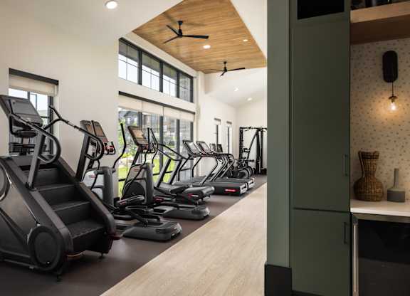 A gym with treadmills, elliptical machines, and a stair climber.