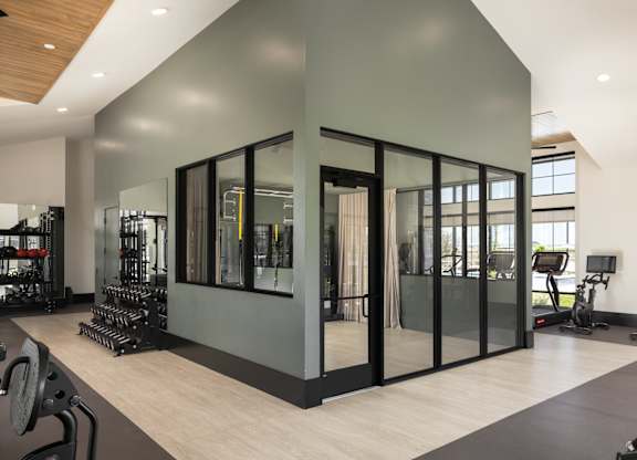 A gym with a variety of equipment including weights and treadmills.